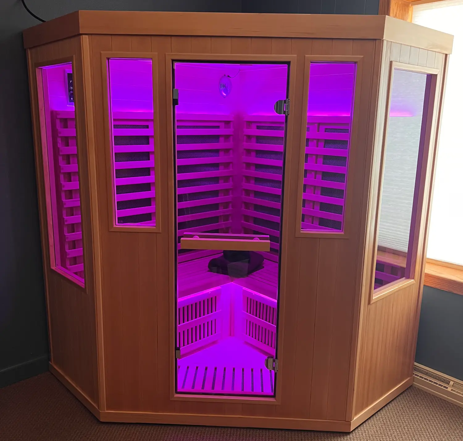682db6dfb9dd6_Purple Sauna door closed A large room with many lights and a bench.